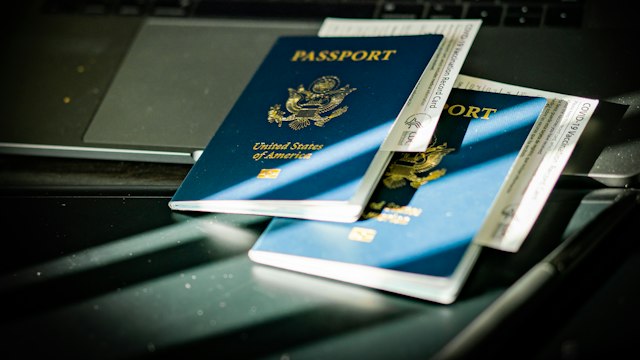 Passaporte sobre o teclado de um computador, ilustrando a verificação de documentos e identidade.